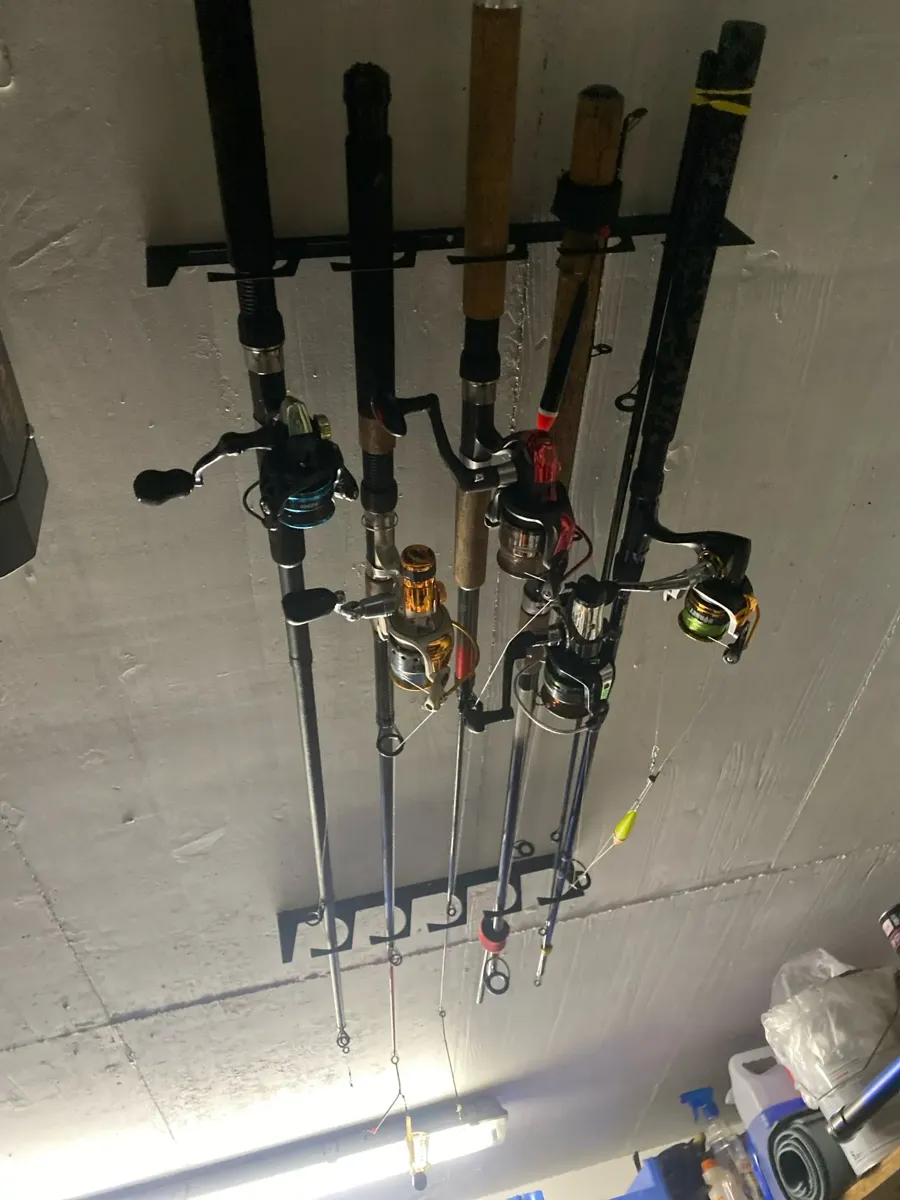 Fishing rods stored on a wall-mounted RodPerch rack in a garage